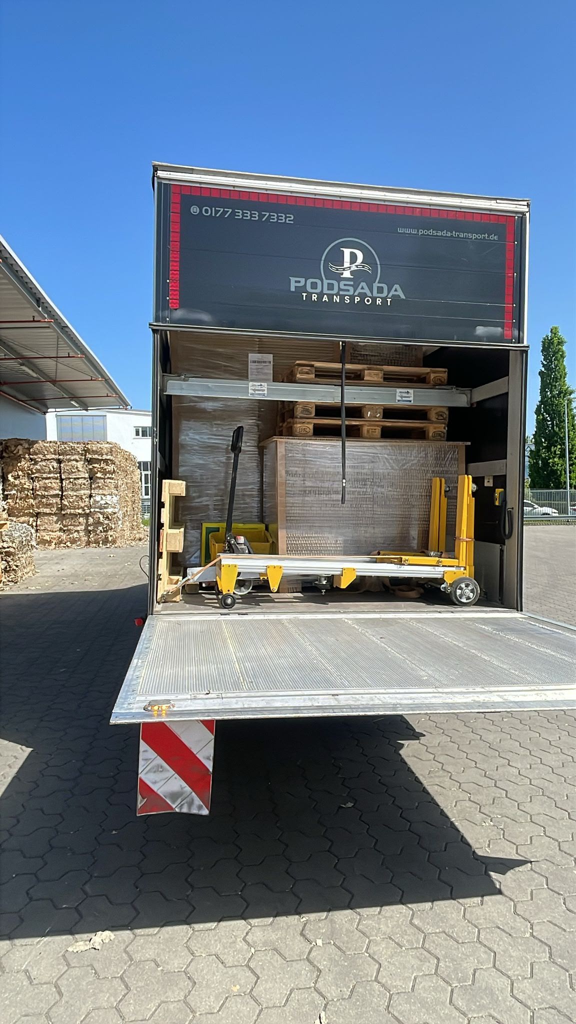 Wnętrze naczepy Podsada Transport z załadowanymi paletami i wózkiem paletowym